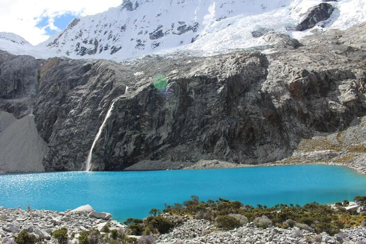 a blue lake in front of a snow covered mountain