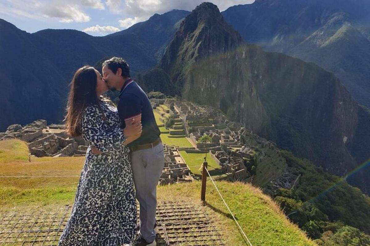 un uomo e una donna che si baciano in cima a una montagna