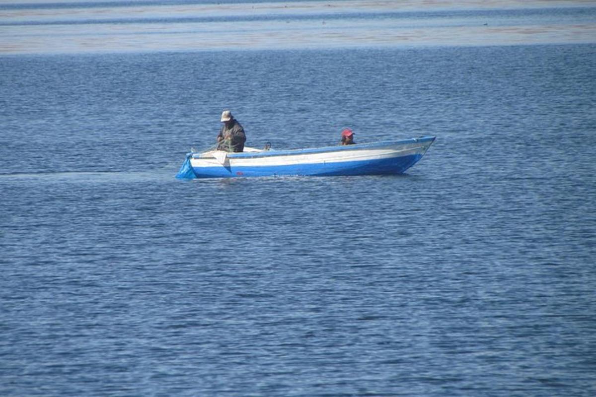 un hombre en un bote azul en el agua
