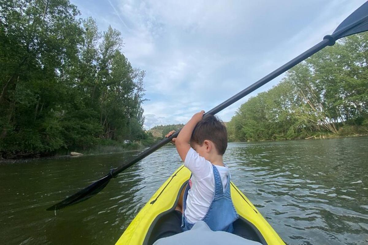 un ragazzino in kayak su un fiume