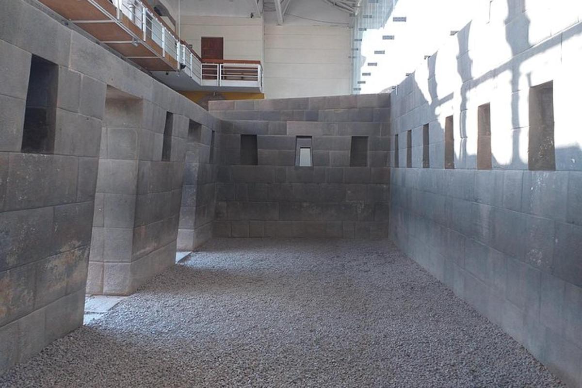 an empty room with a stone wall in a building