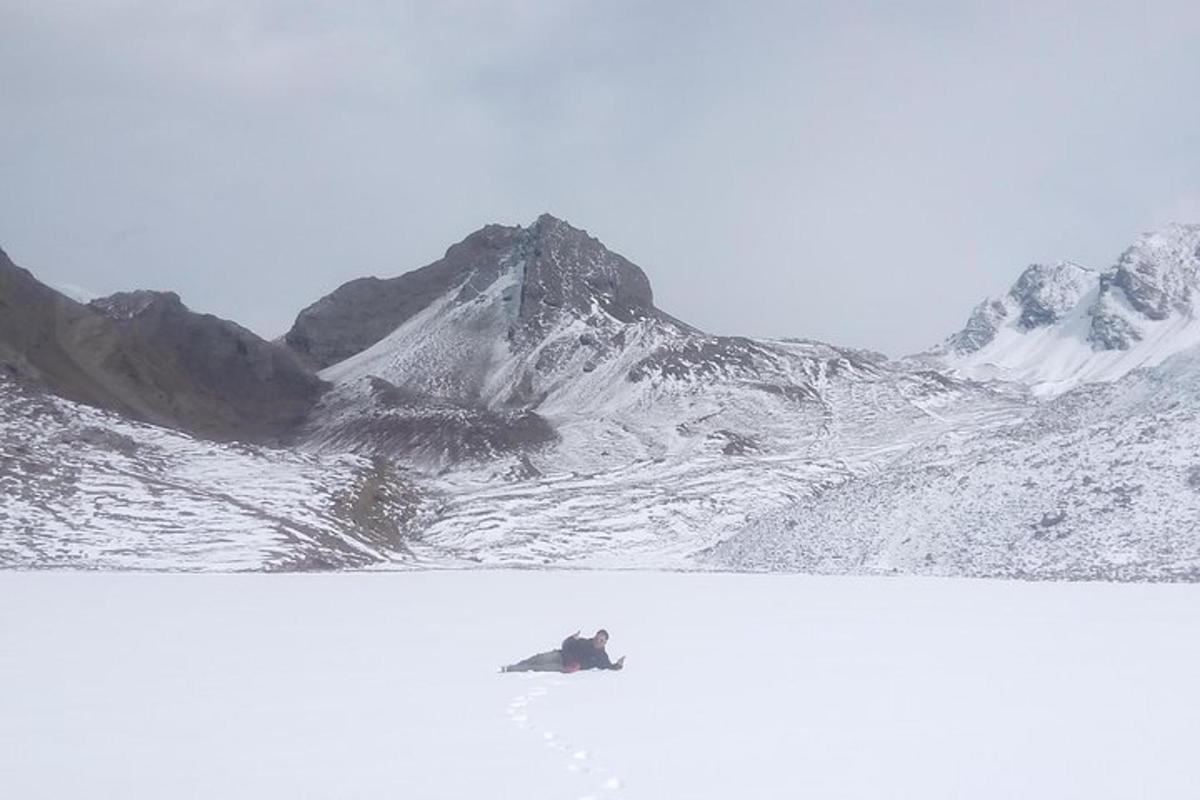 uma montanha coberta de neve com uma pessoa em uma prancha de snowboard