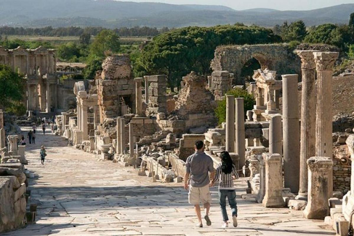 un uomo e una donna che camminano tra le rovine
