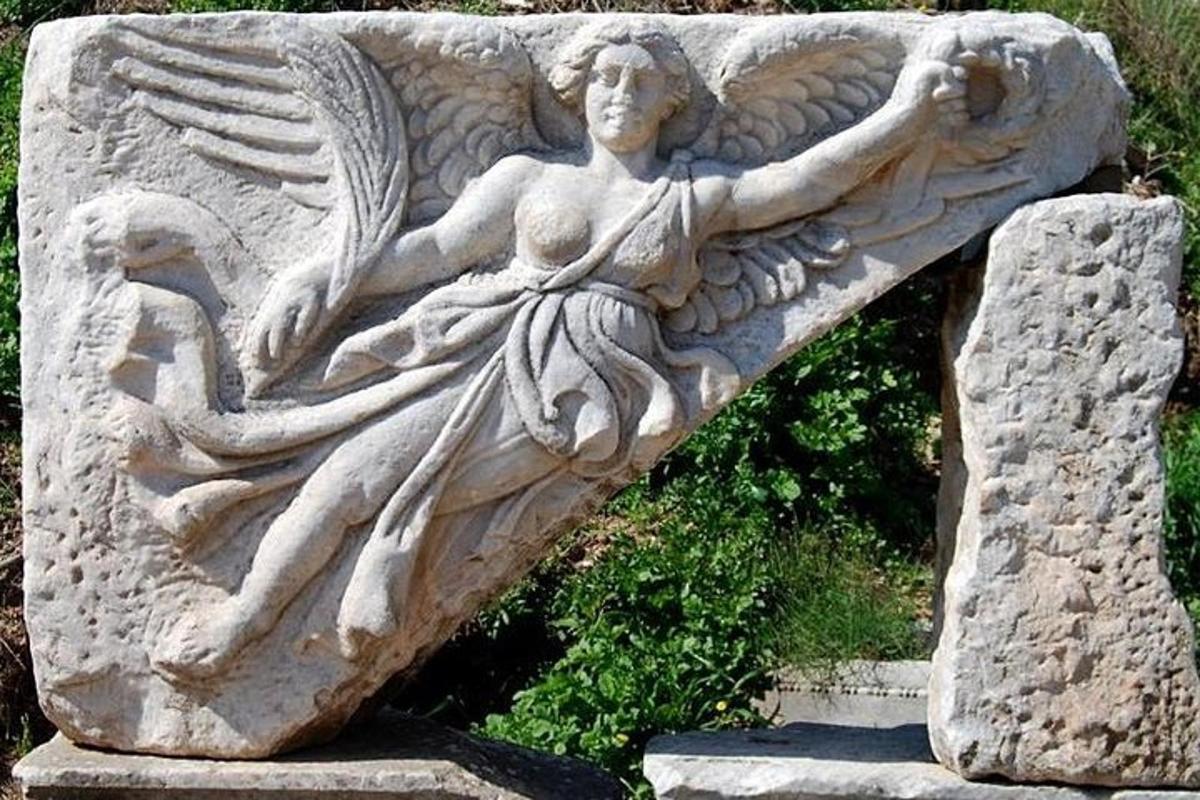 una estatua de un ángel en un muro de piedra