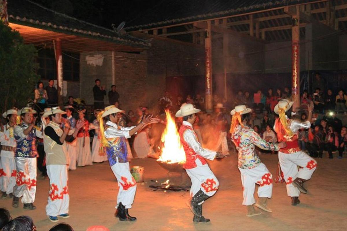 a group of people dancing in front of a fire