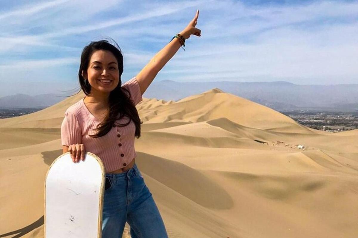 una donna in piedi nel deserto che tiene in mano uno snowboard