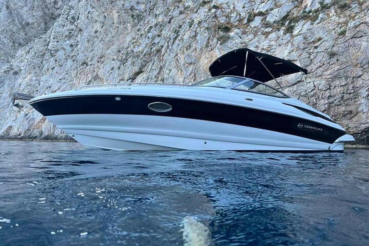 μια βάρκα που κάθεται στο νερό δίπλα σε έναν γκρεμό