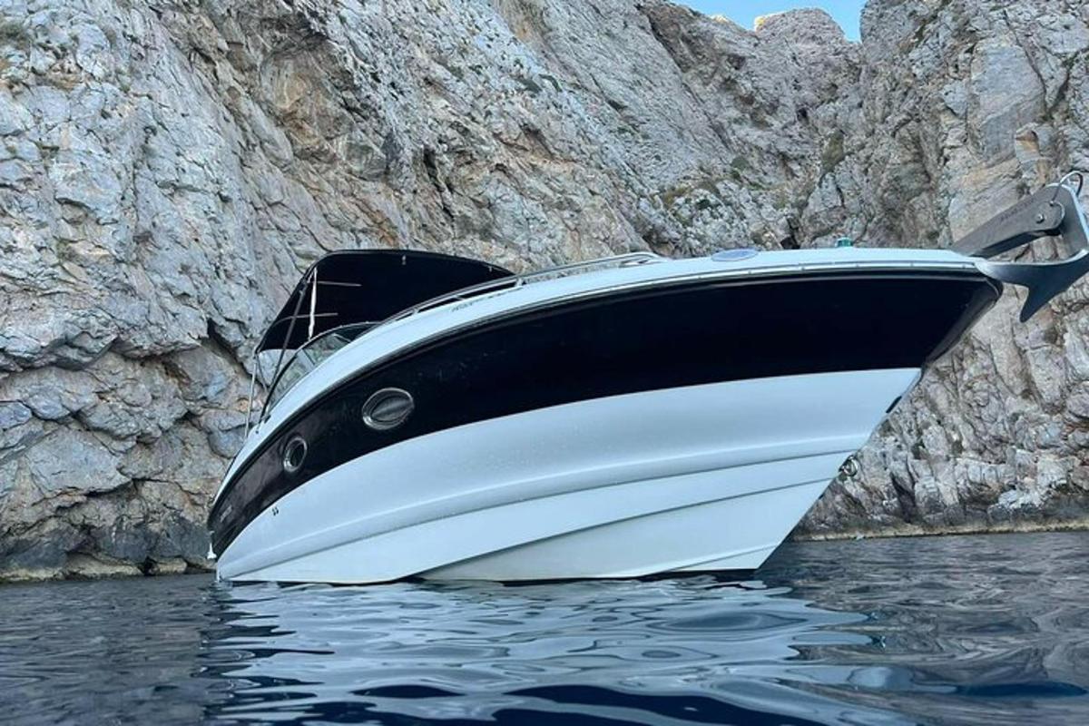 μια βάρκα που κάθεται στο νερό δίπλα σε έναν γκρεμό