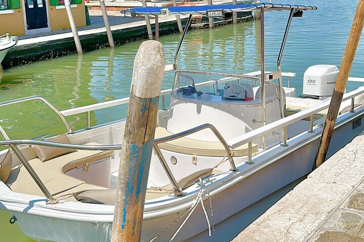 una barca bianca legata a un molo in acqua