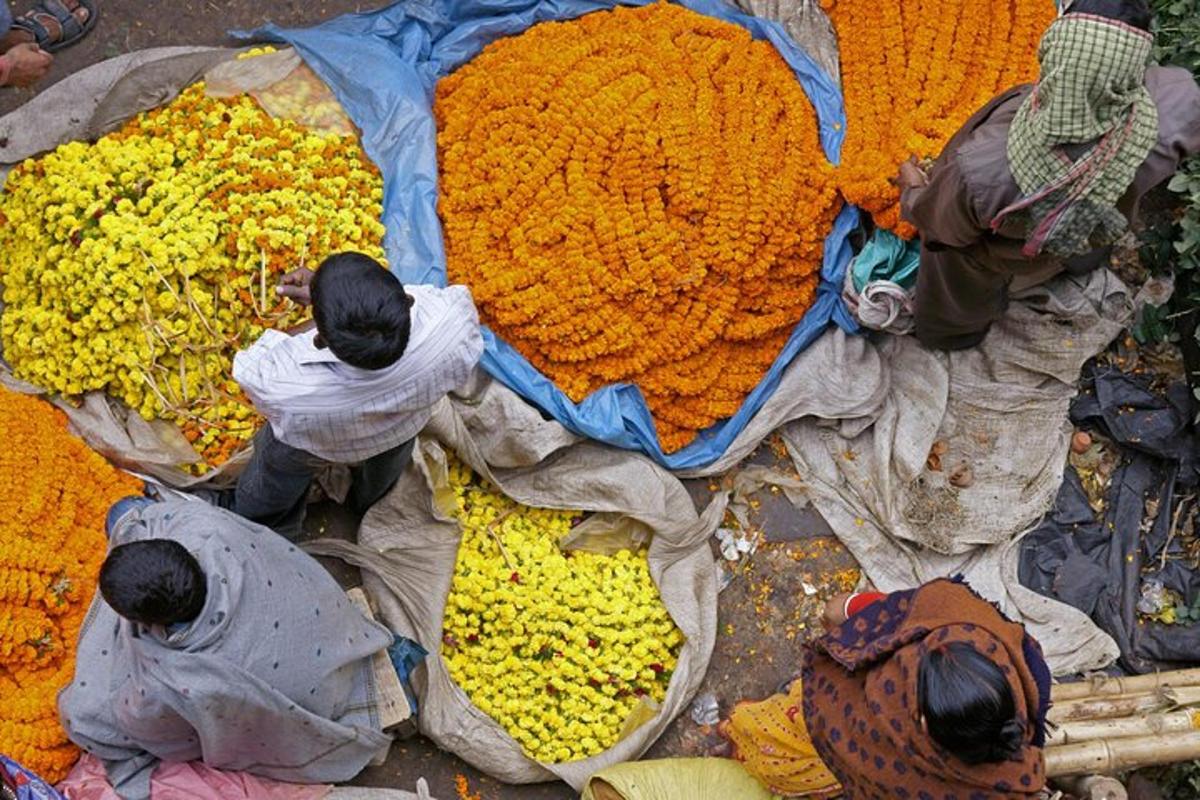 un gruppo di persone in piedi attorno a un mucchio di fiori