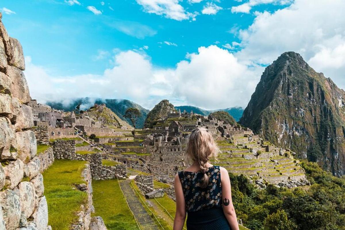 kona stendur ofan á rústum Machu Picchu