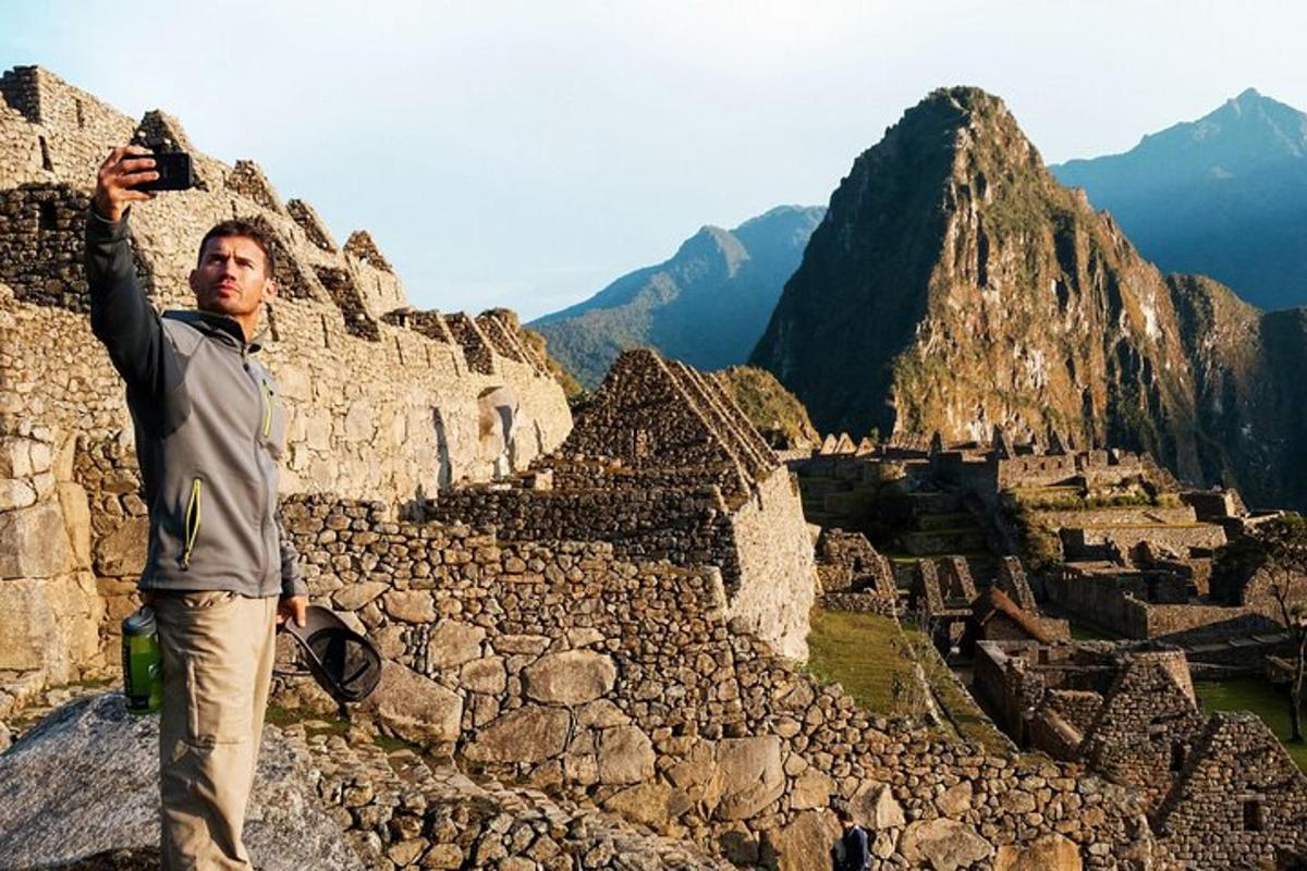 maður stendur á fjallstindi