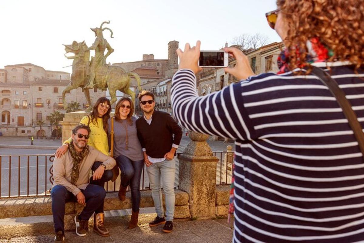 a woman taking a picture of a group of people in front of a statue
