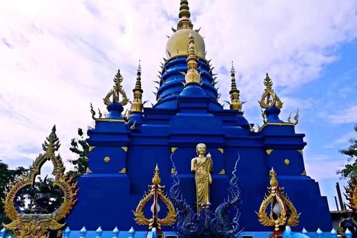 a blue and gold building with a statue in front