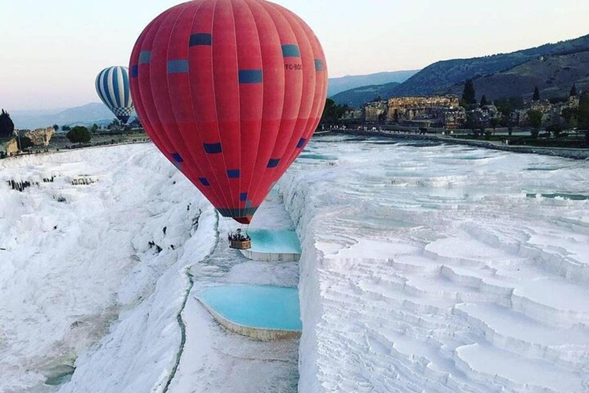 horkovzdušný balón letící nad zasněženou řekou