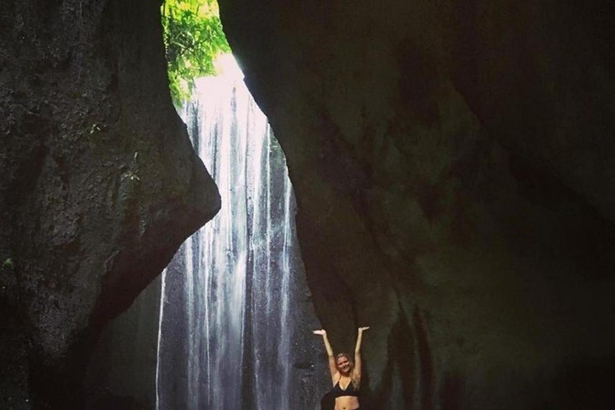 una mujer parada frente a una cascada
