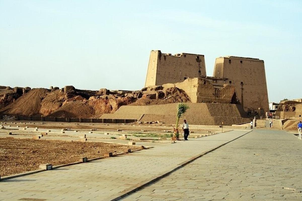 a person standing on a sidewalk in front of a castle