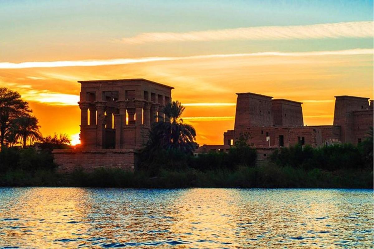 una posta de sol sobre l'acròpolis amb un llac al davant