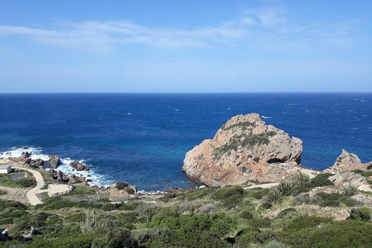 a view of the ocean with a mountain and a road