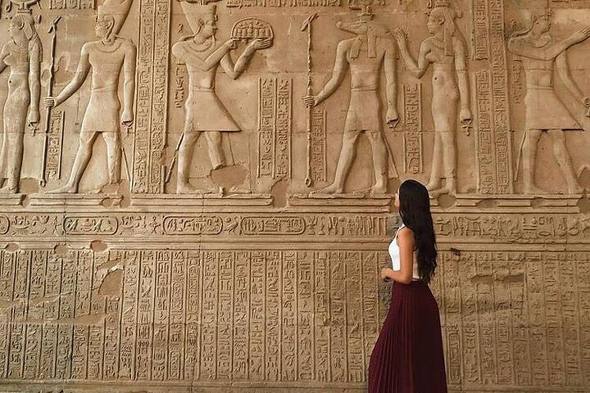 a woman standing in front of a wall with relief