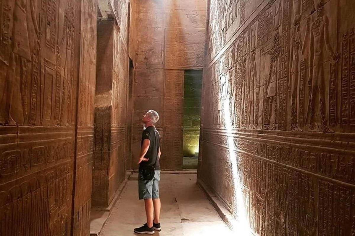 a man standing in a hallway with writing on the walls