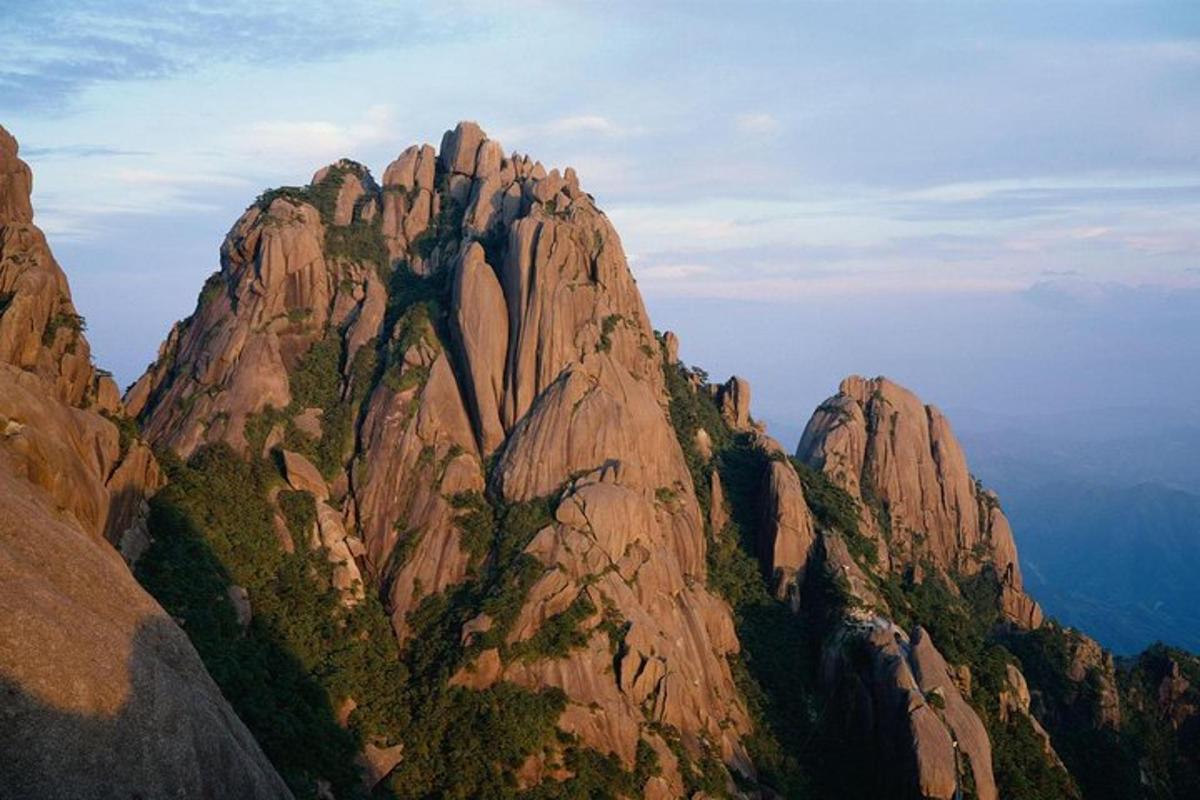 ein hoher Berg mit Bäumen darauf