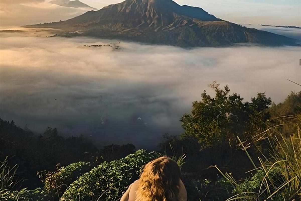 一个人坐在山上，望着雾气弥漫的山峰