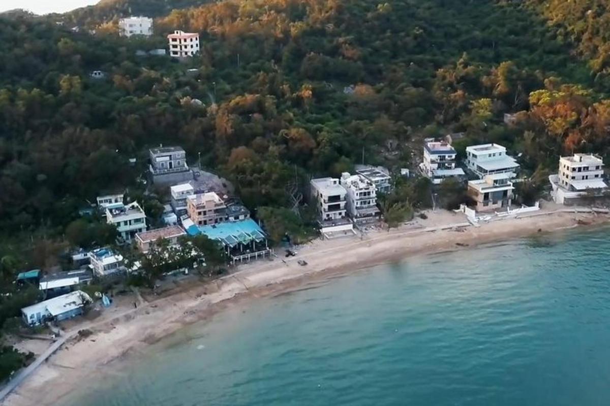 집과 물이 있는 해변의 공중 사진