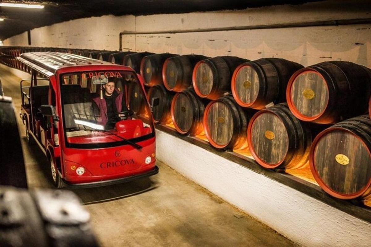 a red trolley in a room with wine barrels