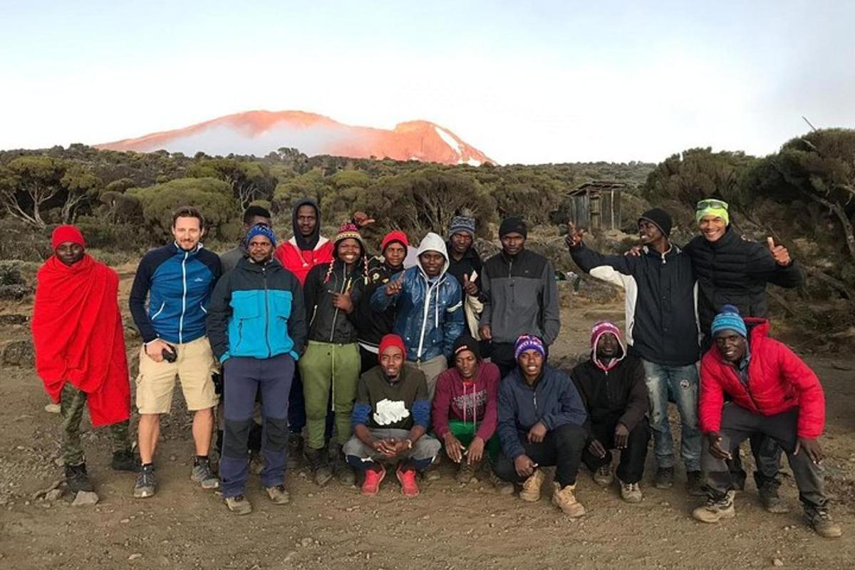eine Gruppe von Menschen posiert für ein Foto vor einem Berg