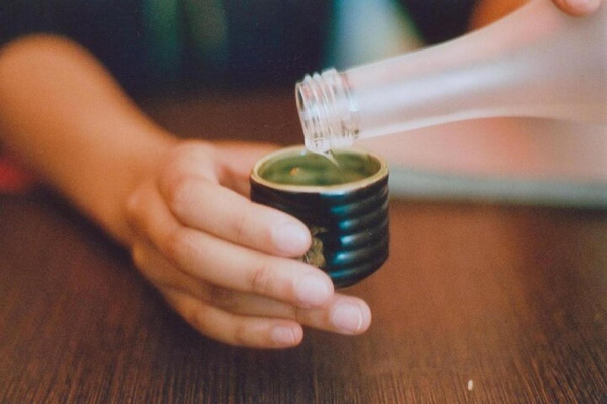 una persona tiene in mano un barattolo di salsa verde