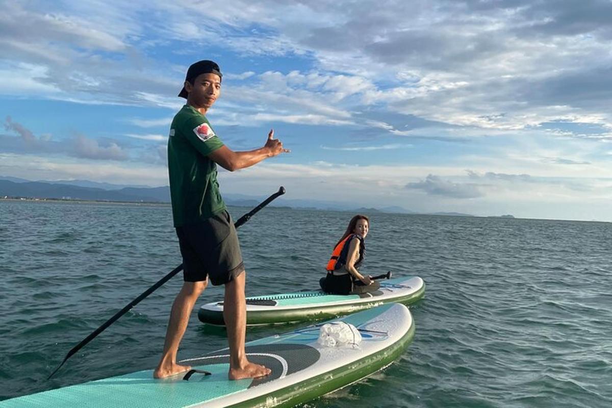 muž stojící na paddleboardu ve vodě