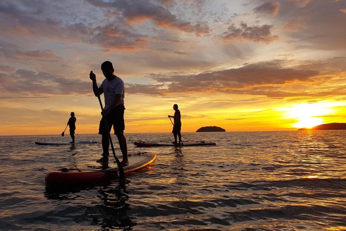 skupina lidí stojících na paddleboardu ve vodě