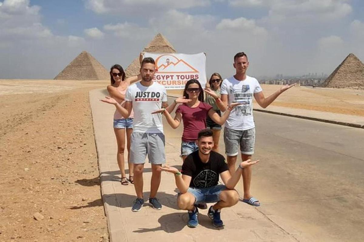 um grupo de pessoas posando em frente às pirâmides