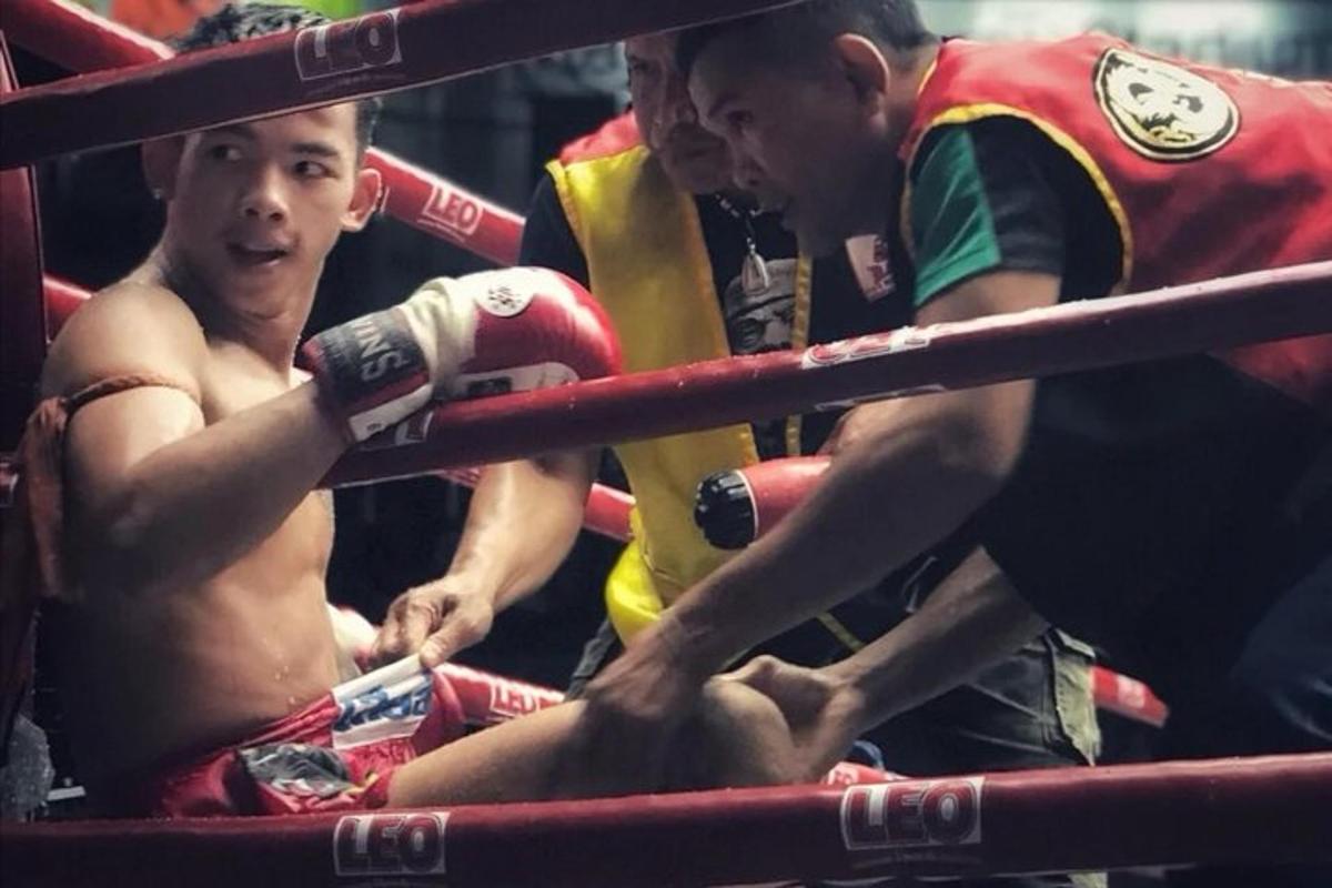 un uomo seduto nell'angolo di un incontro di boxe