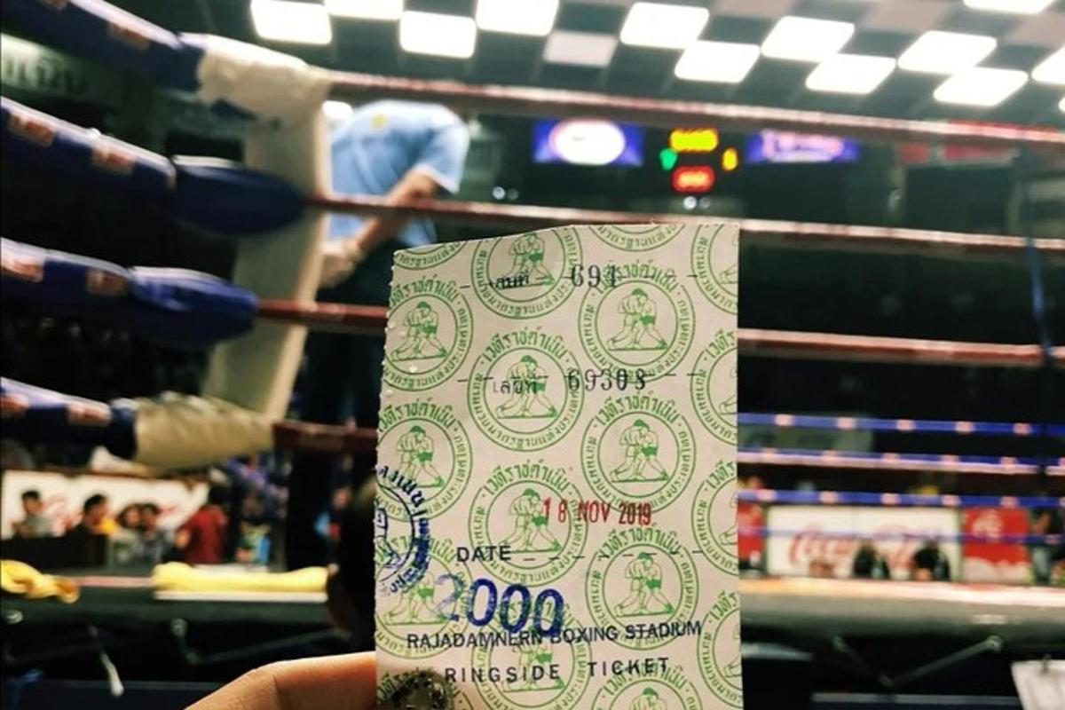 ruka osoby držící ceduli před boxerským ringem