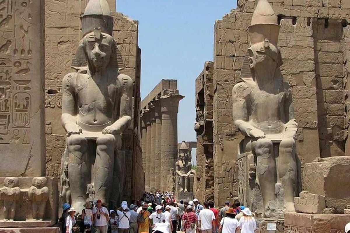 grupė žmonių, stovinčių priešais statulas