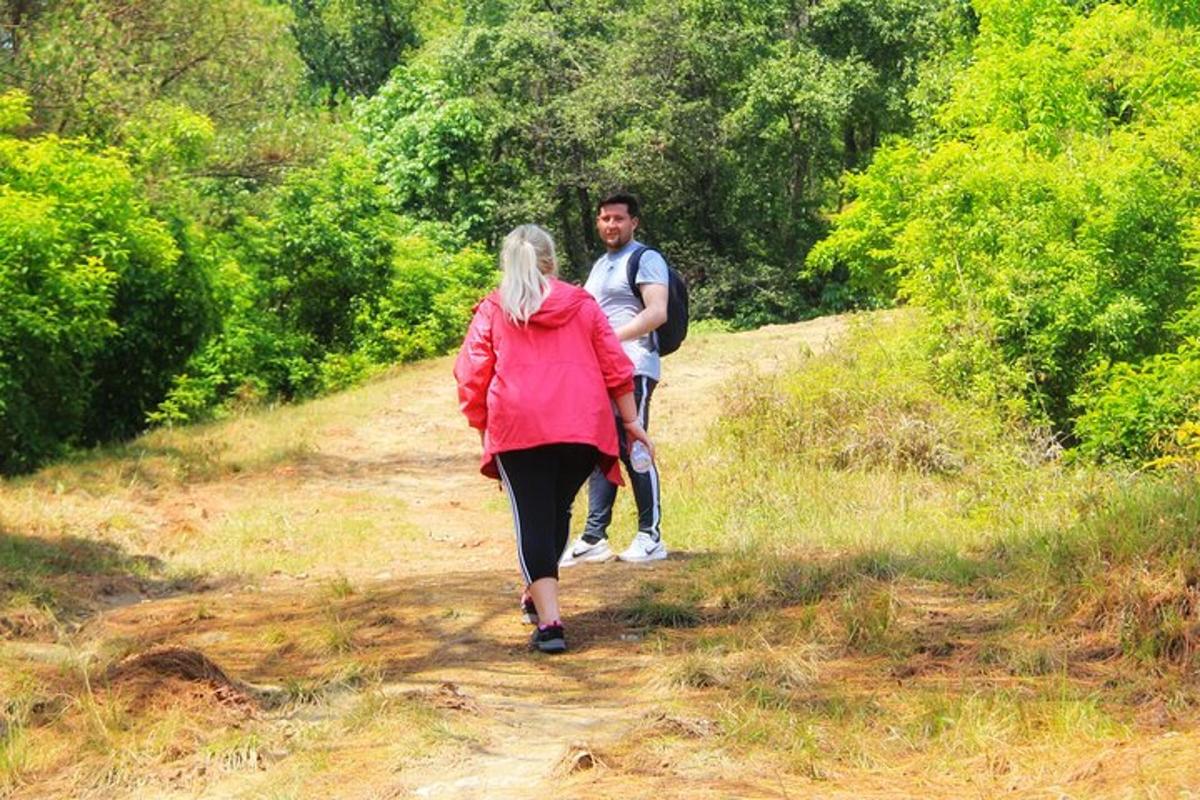 a man and a woman walking down a dirt trail