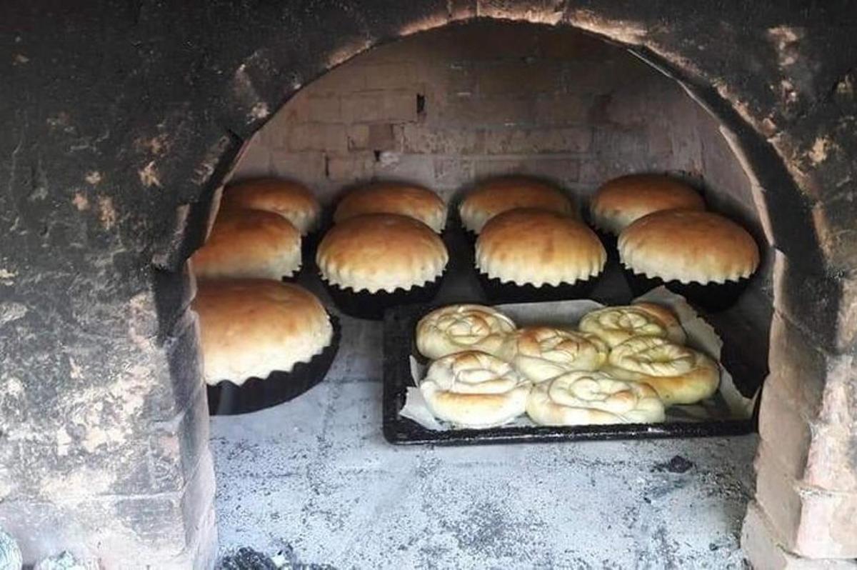 a brick oven with trays of pastries in it