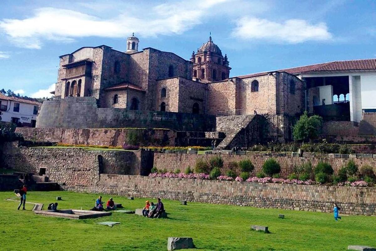 un gruppo di persone sedute in un campo di fronte a un castello