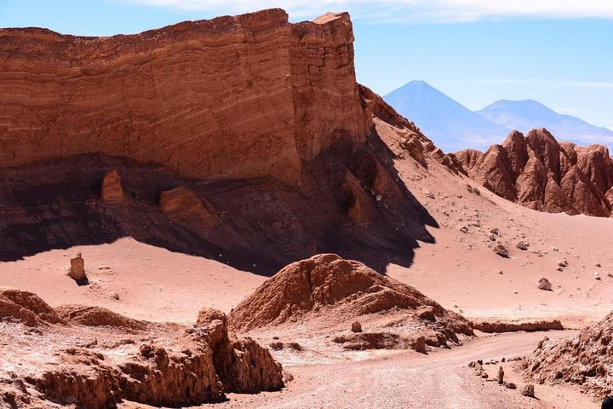 a dirt road in a desert with rocks and mountains