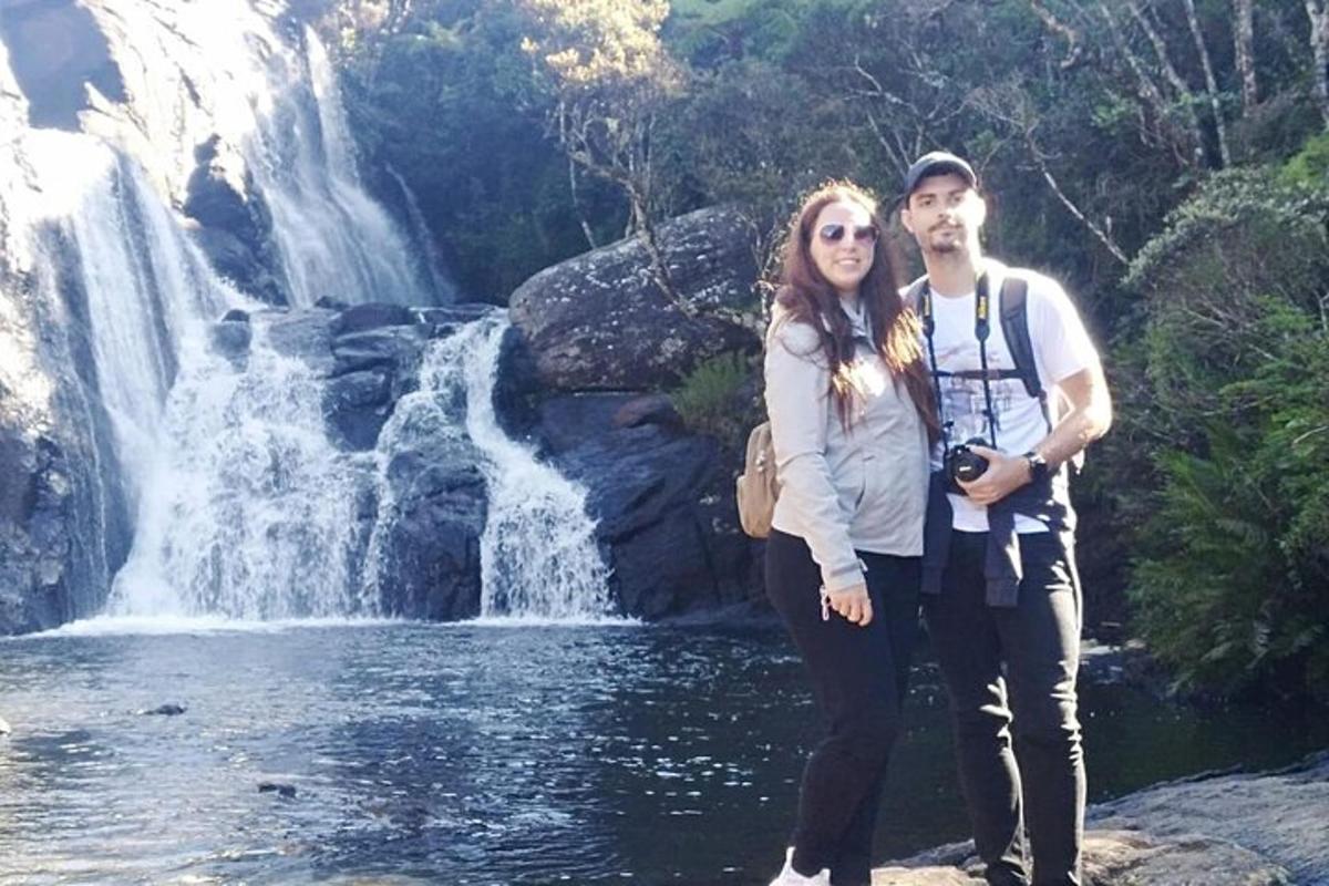 un uomo e una donna in piedi davanti a una cascata