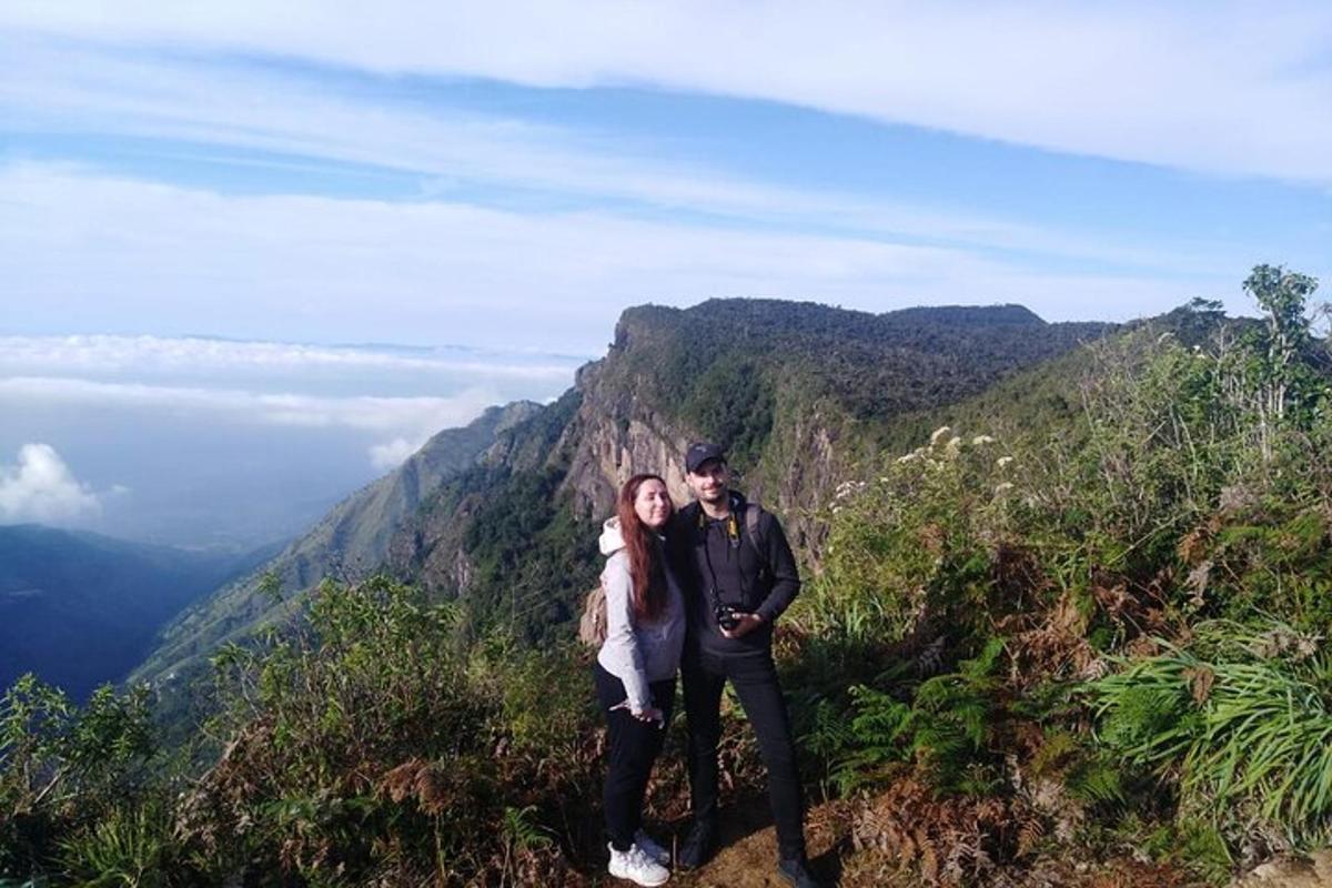 un uomo e una donna in piedi sulla cima di una montagna
