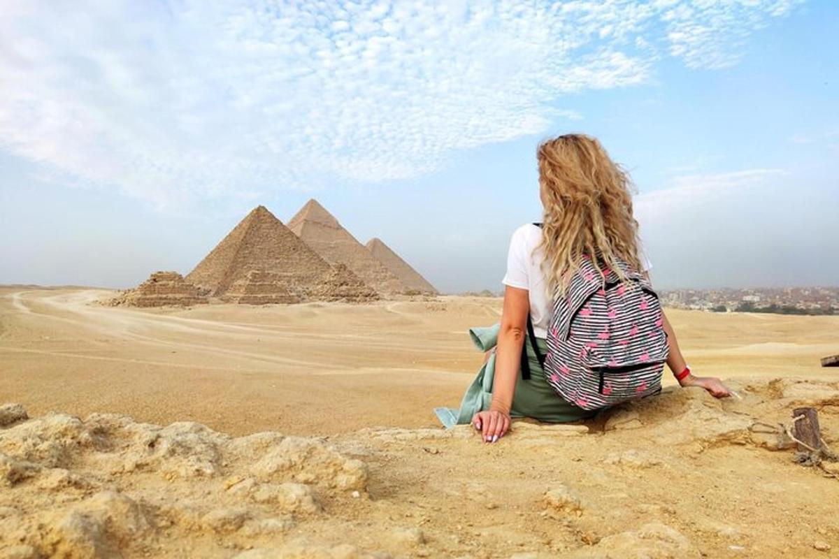 žena sediaca na skale pred pyramídami