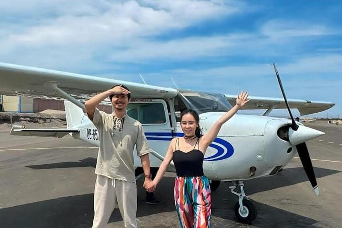 Un hombre y una mujer de pie frente a un avión.