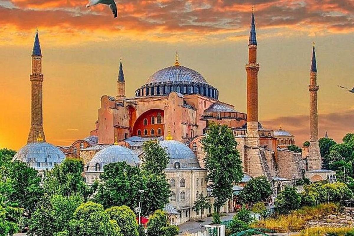 ein Gebäude mit Kuppeln und Moscheen mit einem Sonnenuntergang im Hintergrund