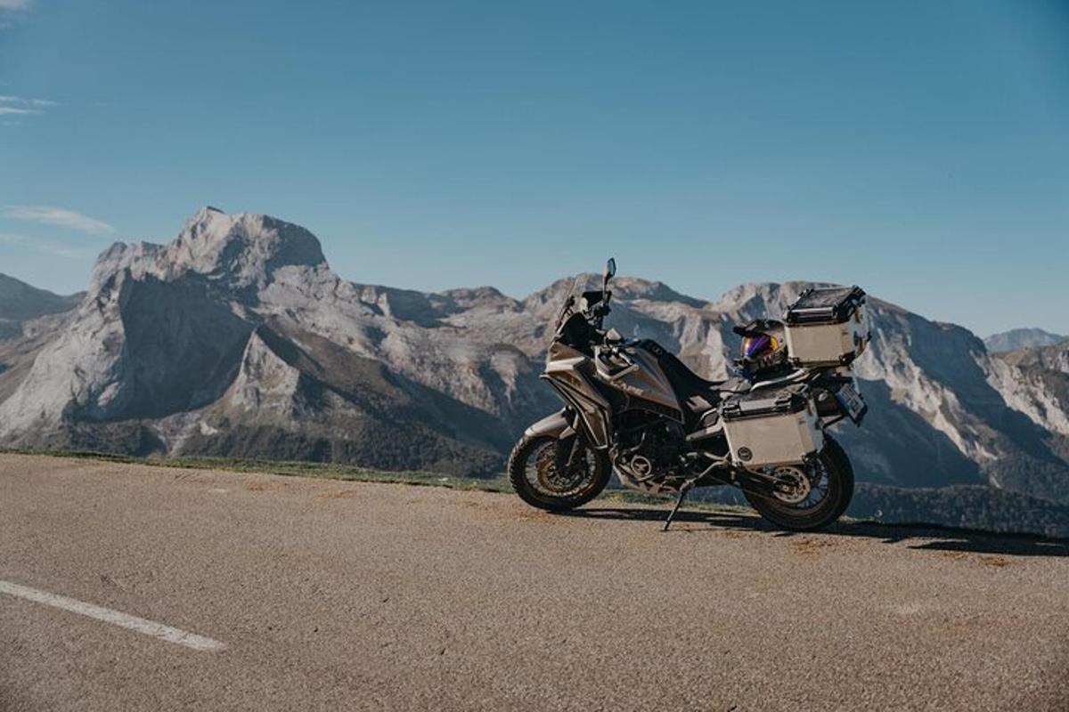 una motocicletta parcheggiata sul ciglio di una strada con montagne