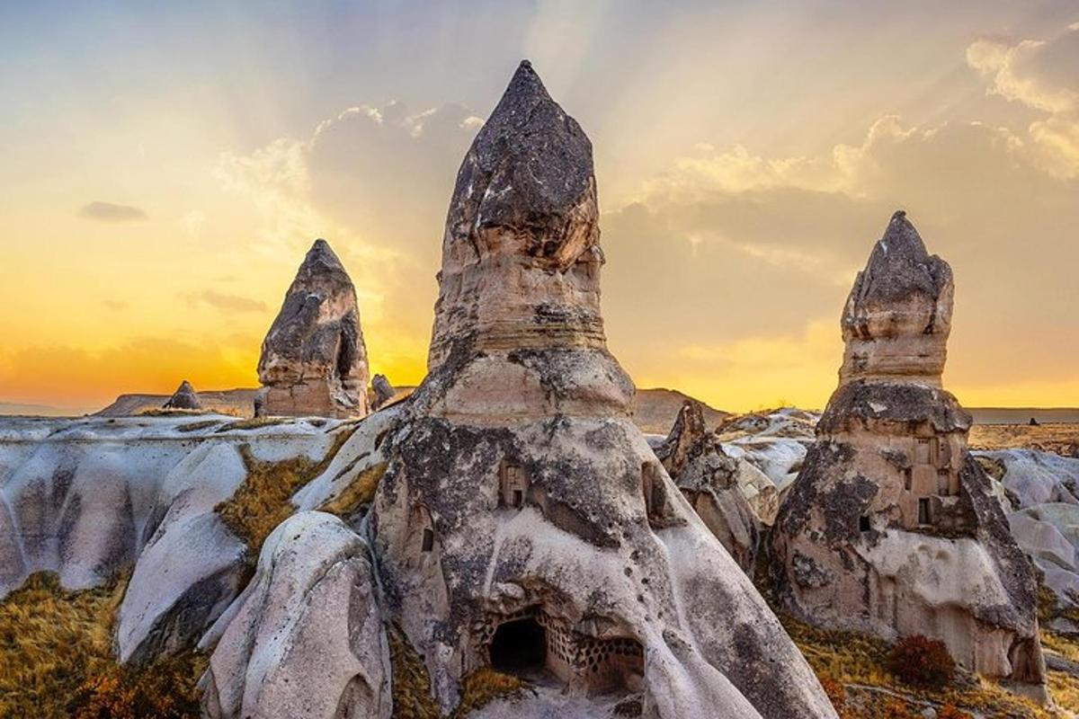 a group of rocks in the snow at sunset