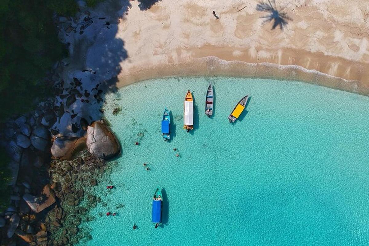 eine Luftaufnahme von Booten im Wasser an einem Strand