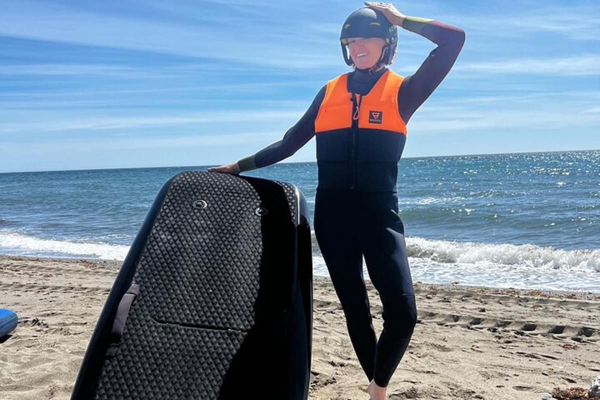 una donna in piedi sulla spiaggia con una tavola da surf